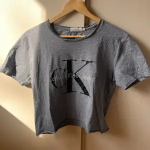 T-shirt från Calvin Klein Storlek S Bortklippt lapp, men 100% bomull Har klippt bort nedersta centimetrarna på tshirten för att få kortare modell, i övrigt inga anmärkningar 