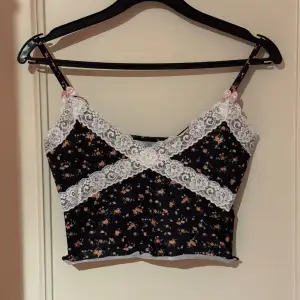 Säljer fin crop top med tryck på blommor och lace i sidan. Perfekt på sommaren tunn material. Står storlek S skulle säga mer XS stretchig material.  Katter finns i hemmet