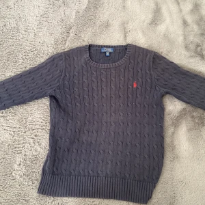 Raulph lauren stickad tjocktröja.  - En använd marinblå Raulphl lauren tjocktröja. Jag säljer denna pga jag gillar inte färgen. Småslitna armar, därför jag säljer billigt. Nyköpt kostar cirka 1100kr. Hoppas ni vill köpa! ❤️