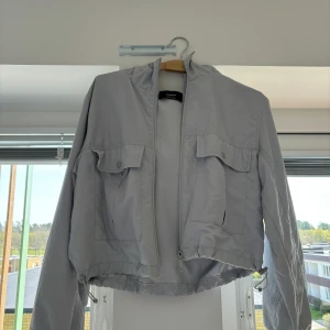 Vårjacka - Ljusblå vindjacka från Pull & Bear.  Aningen croppad.  Storlek M men känns mer som en S. 