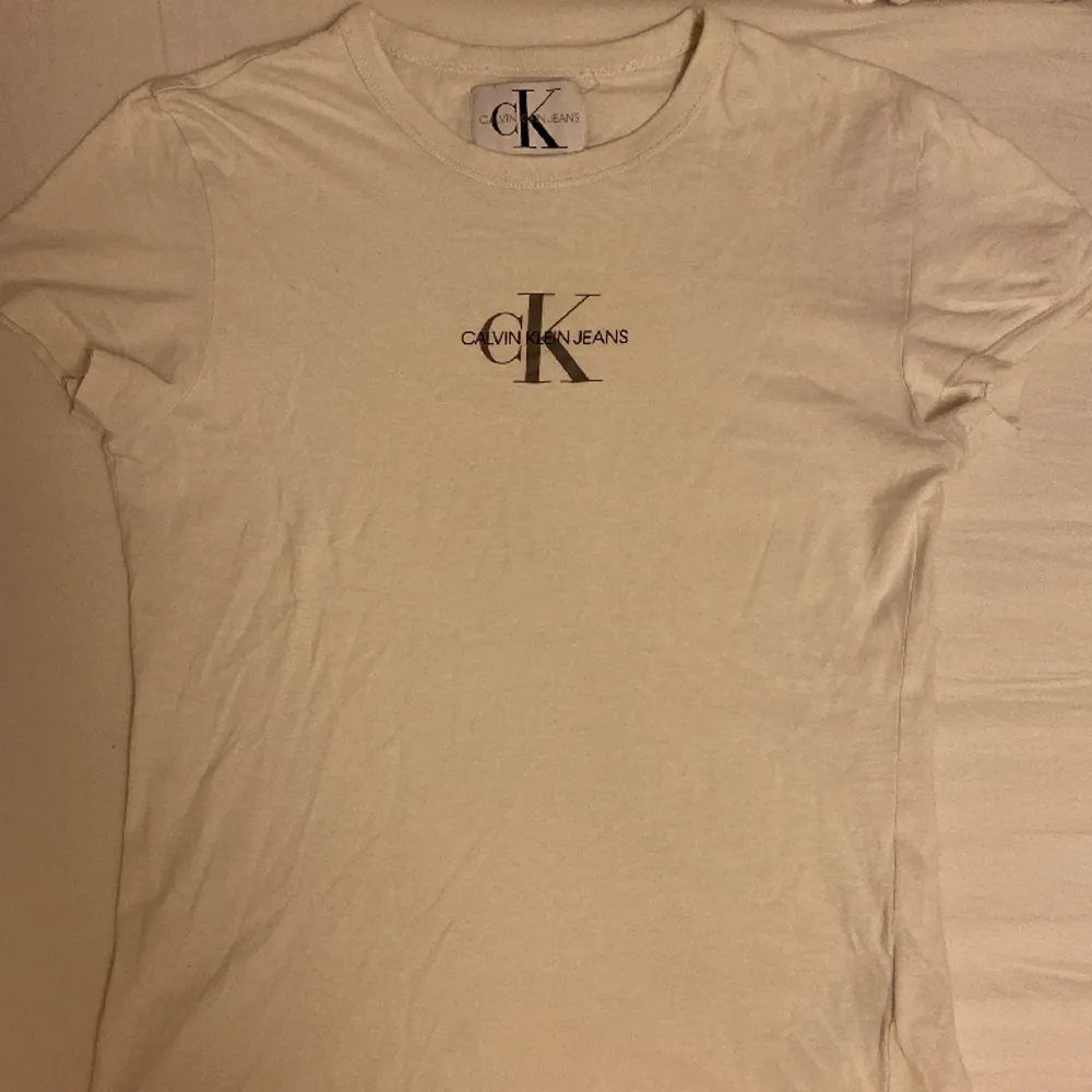 Vit t-shirt från Calvin Klein💗Storlek S💗Litet hål längst upp på baksidan av tröjan men går lätt att sy ihop💗. T-shirts.