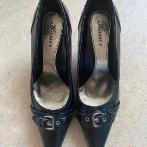 Svarta spetsiga kitten heel pumps  - Superfina med ett metallspänne på, oanvända men som bilden visar så är är färgen lite sliten. För små för mig. Skulle säga att det är en liten 38, nästan 37.