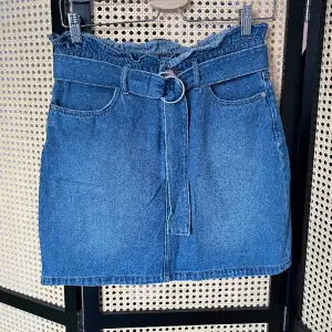 Kort kjol i jeans  Storlek 38 men liten i storleken, skulle säga mellan 34-36  Fint använt skick utan anmärkning  Skärpet kan tas av 
