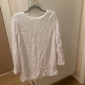 Vit Paljettklänning  - Säljer min vita paljettklänning i storlek XS som är helt oanvänd. Har en likadan så säljer en utav dem.