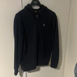 Säljer denna Mörkblåa Ralph Lauren hoodie med dragkedja, storlek XL, använd fåtal gånger och i väldigt bra skick.