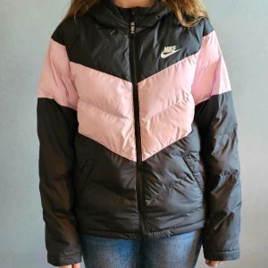 Nike täckjacka - Säljer den här svart och rosa täckjackan för att den inte kommer till användning. Bra skick, använd fåtal gånger och tvättad en gång innan försäljning.