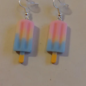 Örhängen med hänge av en glasspinne. - Tuffa örhängen med hänge av en glasspinne.Helt nya och oanvända .