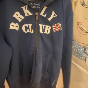 Hoodie - Blå ziphoodie med tryck på bröstet