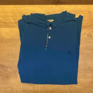 Burberry piké  - Säljer denna riktigt snygga Burberry pikén. Nypris: 3000kr. Skick 9/10. Hör av dig om du har någon fråga