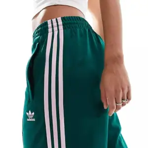 Säljer ett par gröna och rosa Adidas Originals Superstar träningsbyxor i storlek 