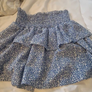 Minikjol - Jätte fin volangkjol blå med vita blommor🌸 använd max 10 gånger toppen bra skick💗💗