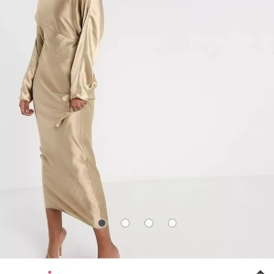 Asos klänning - En helt ny beige satin klänning som är slutsåld med lappar kvar. Beställde två storlekar och hann inte returnera den andra.