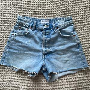 Säljer nu dessa skitsnygga jeansshorts med slitningar från zara, perfekta nu till sommaren!💞💞 jättebra i skick, endast använda 2-3 ggr. Skriv till mig vid frågor kring köp!