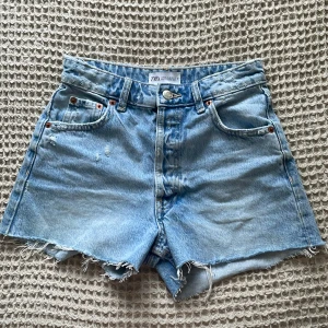Jeansshorts  - Säljer nu dessa skitsnygga jeansshorts med slitningar från zara, perfekta nu till sommaren!💞💞 jättebra i skick, endast använda 2-3 ggr. Skriv till mig vid frågor kring köp!