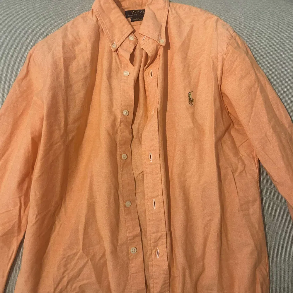 Säljer denna ralph lauren skjorta för den är för stor för mig, färgen är lite ljus orange och den är i mycket bra skick, materialet är lite tunnare än en vanlig skjorta . Skjortor.