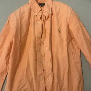 Säljer denna ralph lauren skjorta för den är för stor för mig, färgen är lite ljus orange och den är i mycket bra skick, materialet är lite tunnare än en vanlig skjorta 