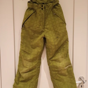 Gröna täckbyxor - Gröna varma täckbyxor från Everest!  Väl använda, se defekter på bilderna.  Storlek 134/140.  Går även att lägga till hängslen om så önskas då den har öglor till det. De har justerbar midja🌟 Perfekta vid skidåkning! 