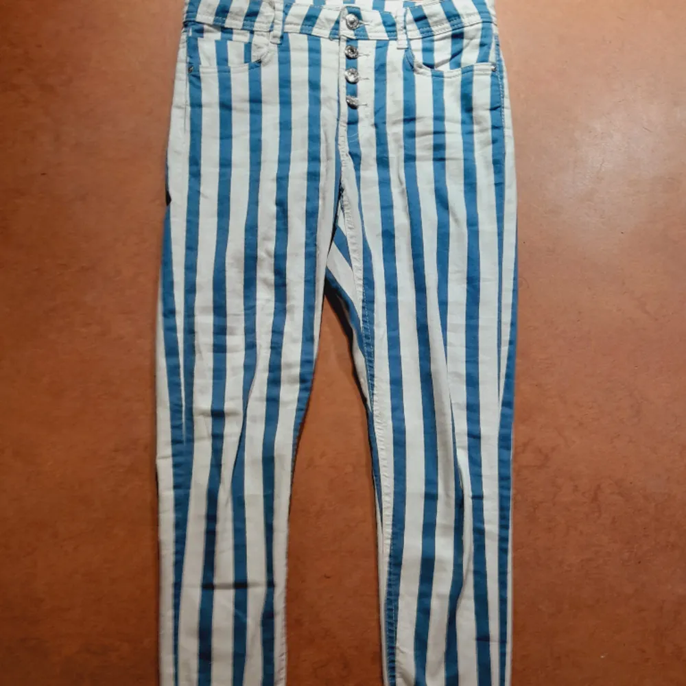 Blåvita randiga jeans i stretch med knappgylf. 7/8 längd och normal midja. Från Sinsay i storlek 36. Jättefina till sommaren. Nyskick!. Jeans & Byxor.