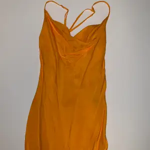 Orange klänning från H&M. Korsade snören bak, aldrig använd, prislapp kvar.  Tryck inte på köp nu, kontakta mig! Samfrakt vid flera köp🧡