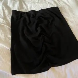 En kort svart kjol med rynkat både fram och bak som framhäver kurvorna🤩 Väldigt stretchigt material. Säljes då den inte används längre. Stl M men passar även en L då den som sagt är stretchig! Bra kvalite.