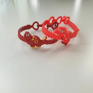 2st röda dinosaurier armband, nya  - Armband  Motiv: dinosaurier  Färg: röd  Antal: 2st  Skick: oanvänd 