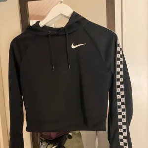 Träningshoodie - En träningshoodie som aldrig är använd i svart med detalj på armarna 