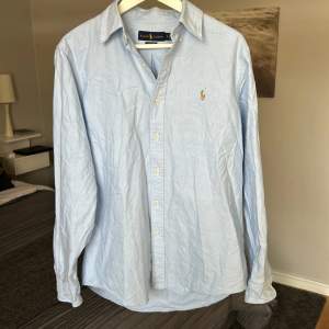 En ljusblå Polo Ralph Lauren skjorta i felfritt skick! M classic fit. Nypris runt 1700kr, säljes då den ej kommer till användning. Obs detta är inte min annons utan den jag köpte den av, gav 600kr men säljer för 400