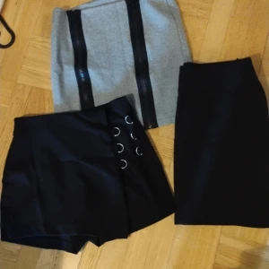 Tre stycken korta kjolar i storlek m - En grå kort kjol med två svarta dragkedjor storlek m, med dragkedja på sidan, en kjolbyxa i storlek, 100 kr styck eller 250 kr för alla tre 