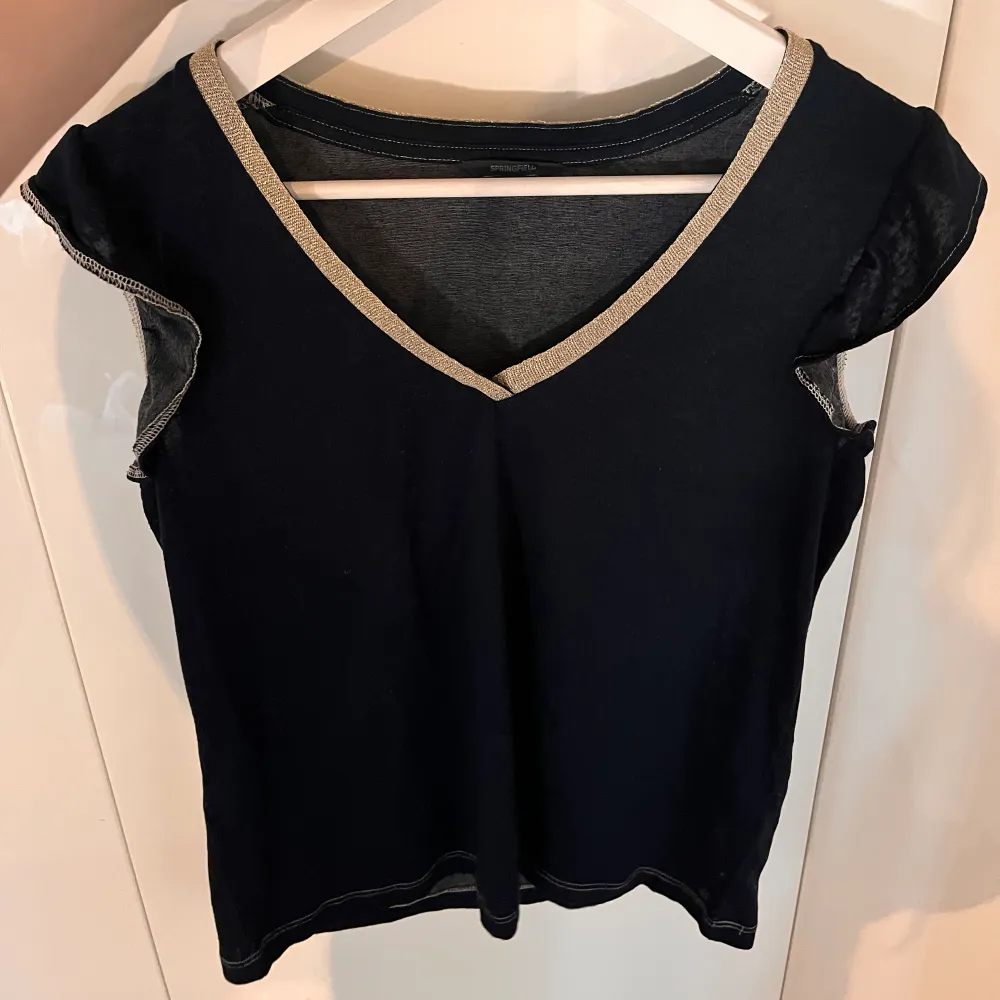Top with frill sleaves and a golden neckline!. T-shirts.
