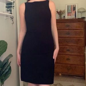 Svart vintage klänning - Basic tight midiklänning med hög båtringad hals och höga slitsar på sidorna, från märket Clockhouse! 💋