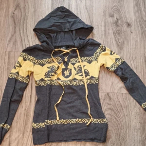 Långärmad bomullströja - Långärmad huvtröja med hufflepuff märke på