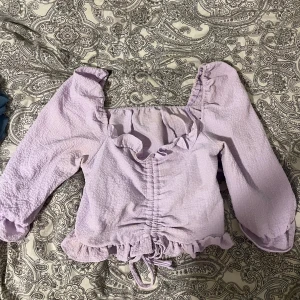 Ljuslila sommartopp  - Ljuslila söt sommartopp som jag tyvärr knappt använt pga för liten för mig. Den har knytning så man kan antingen göra den lite längre ner eller kortare uppåt. 