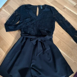 Jumpsuit - Jumpsuit, endast testad.  Med spets upptill, o band i midjan som kan knytas fram eller bak.   