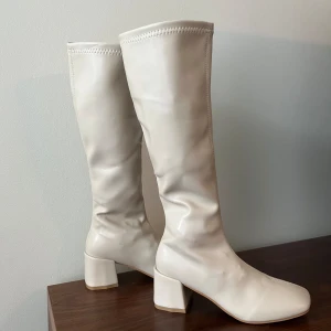 Knähöga stövlar i off-white - Jättefina knähöga stövlar i storlek 38. Helt oanvända (se undersidan av skon). Tyvärr lite för små för mig (använder 38-39). Säljer även samma par i svart.