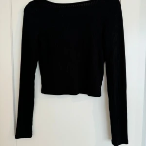 Fin top från NAKD - Svart top med låg rygg från NA-KD Fint skick, endast använd vid ett eller två tillfällen. Storlek S 