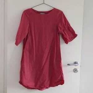 Vinröd klänning - Två fickor vid sidan. Material: bomull  