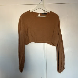 Häftig brun tröja - En häftig kort tröja. Går ner till navlen ungefär