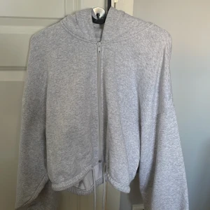 Grå hoodie - Säljer en liten kortare grå hoodie med snurren där nere. Knappt använd🩷