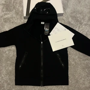 Cp company zip hoodie ny! - Tja. Nu säljer vi denna sjukt snygga cp company zip i färgen svart. Helt ny!!! Tags kvar och den är endast testad. Köpt på NK och alla OGs finns kvar😃😃💫!! Nypris 3200 vårt pris 2395kr. Tveka inte att ställa några frågor💫💫💫