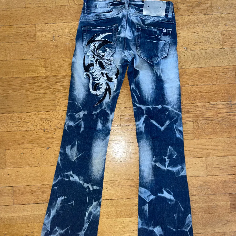 Mörk blå crazy age jeans low waist med vit och svart design på bena nästan aldrig använd. Storlek eur 34. Har inga slitningar på jeansen . Jeans & Byxor.