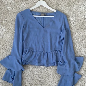 Blå topp - Ljusblå topp i kort modell. Har en fläck vid halsringningen som syns vid bild 2. I övrigt bra skick. Storlek 40 Från ASOS
