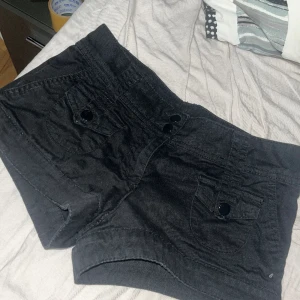 Lågmidjade jeans shorts - Jätte fina svarta lågmidjade jeans shorts från H&M! Storlek 32, säljer de för att de är för små! De har knappar fram och bak, pris kan diskuteras 