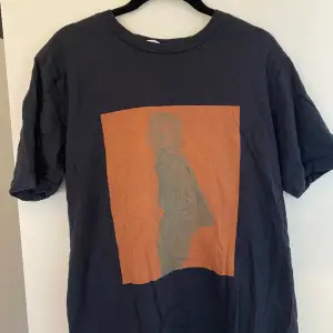 Mörkblå t-shirt med oranget tryck
