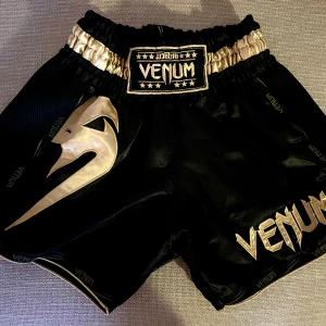 Muay thai shorts - För olika typer av kampsport, boxning, muay thai, kickboxning. Shorts från Venom. Svart och guld. 