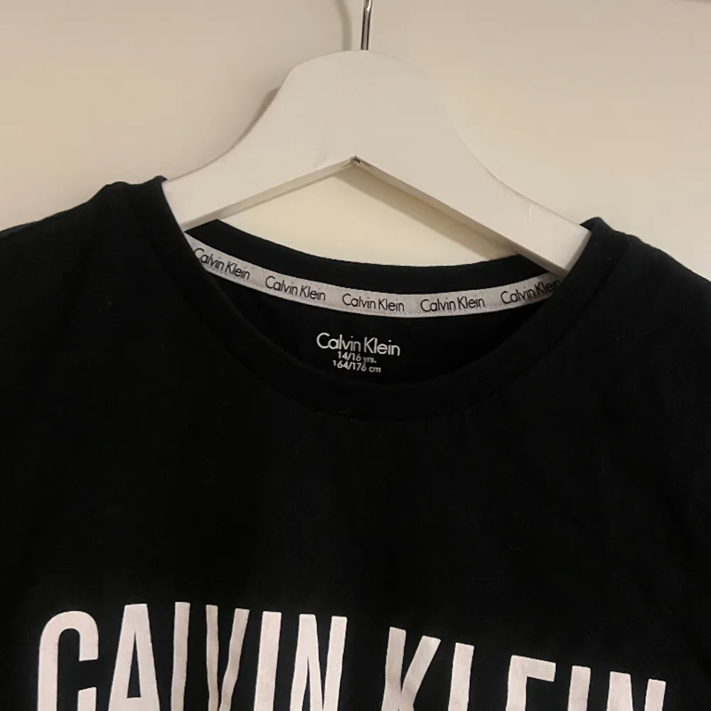En stilren svart T-shirt från Calvin Klein  Använd ett fåtal gånger, storlek 164/176cm men skulle säga att den passar allt från XS-M . T-shirts.