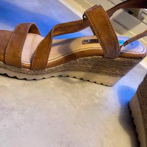 Sandaletter med bruna mockaband. 8 cm hög klack och gummisula. Från Tamaris, väldigt fint skick. 