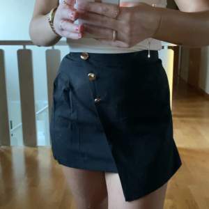 Säljer denna söta svarta kjol som har shorts under!🙌🏼🐚 Gulliga guldknappar på Använd fåtal gånger Fint skick!!