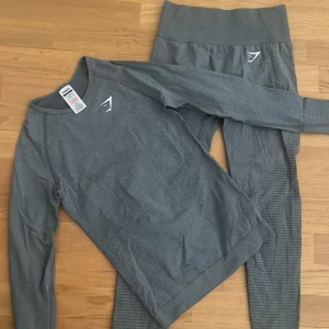 Gymshark set vital seamless - Grått träningsset med långärmad tröja och tighta storlek S från Gymshark i modellen Vital seamless. Skicket är som nytt, endast lite sprickor på loggan på tightsen. (Bild 3) 🌟