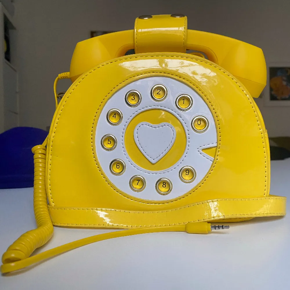 Yellow telephone handbag with 3mm output to connect with headphones and phone adapter. Rarely used, in mint condition.. Väskor.