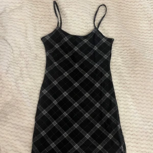 Svart rutig klänning - Kort rutig klänning med tunna straps från H&M. Lapp sitter kvar, aldrig använd 💕